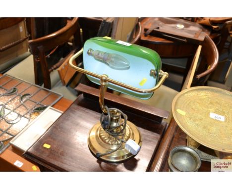 A brass desk lamp with green glass shade