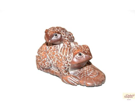 A wooden Netsuke in the form of a frog 