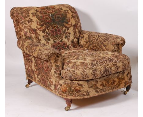 A Victorian oak framed armchair in the manner of Howard & Sons, having a deep seat, the whole upholstered in a silk damask wi