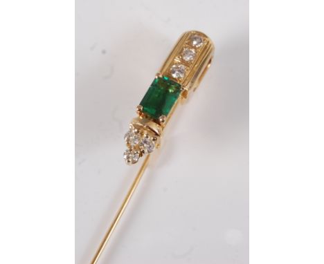 A yellow metal, emerald and diamond stick pin, featuring a step cut emerald with a trefoil of round brilliant cut diamonds to