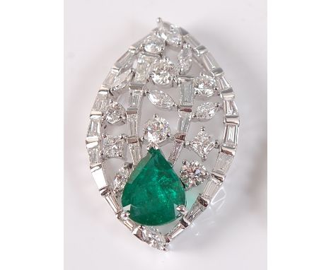 A white metal, emerald and diamond leaf shaped openwork pendant, featuring a pear shaped emerald with a border of 25 tapered 