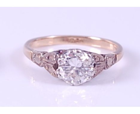 A yellow and white metal single stone diamond ring, featuring a round brilliant cut diamond in a six double claw setting with