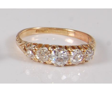 A Victorian yellow metal diamond half hoop eternity ring, featuring five graduated Old European cut diamonds in claw settings