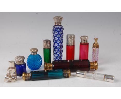 A collection of Victorian and later coloured glass and principally silver topped scent bottles, to include cranberry glass ex