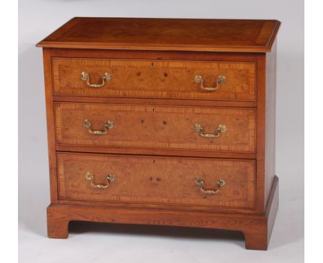 A Georgian style burr oak, crossbanded and further inlaid chest, of three long graduated drawers, having cast brass swan neck
