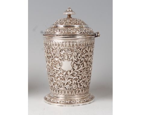 A late 19th century Indian silver jar and cover, having a finial topped hinged dome cover, the jar with vacant cartouche with