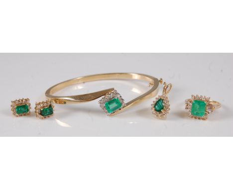 A 14ct gold, emerald and diamond suite of jewellery, comprising hinged bangle, pair of ear studs, pendant, and ring, the bang