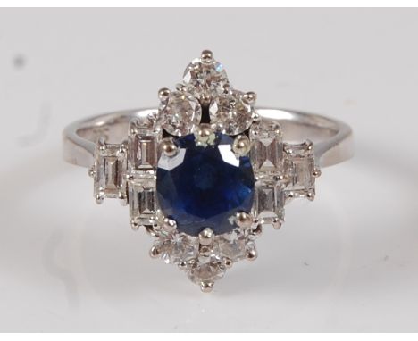 A white metal, sapphire and diamond marquise shaped cluster ring, featuring a centre oval faceted sapphire with a trefoil of 