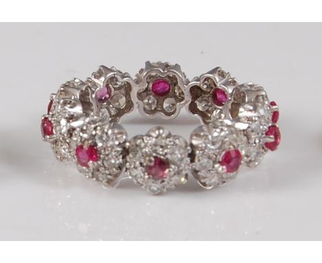 A white metal, ruby and diamond circular cluster full hoop eternity ring, comprising ten clusters each with a centre round fa