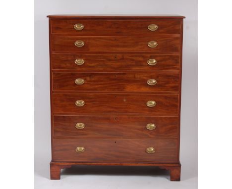 A large mahogany squarefront chest, of seven long graduated drawers, each with pressed brass oval escutcheons, on square brac