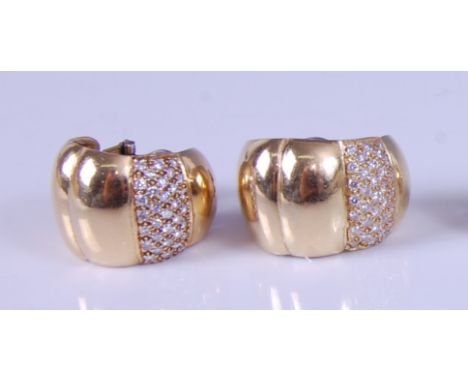 A pair of yellow metal diamond set half hoop style ear clips, each with a pavé set section of 33 round brilliant cut diamonds