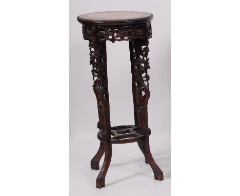 A Circa 1900 Chinese 'rosewood' and rouge marble inset urn stand, having all over floral carved and pierced decoration to bam