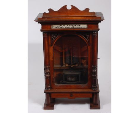 A late 19th century Nicole Frères if Liepzig walnut cased upright polyphon, being coin operated, playing 15½″ discs, the case