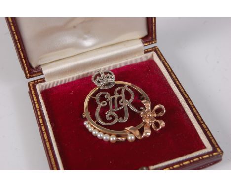 A yellow and white metal Elizabeth II Royal monogram brooch, of circular form with ERII initials surmounted by a crown, with 