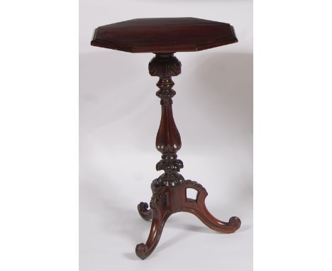 An early Victorian rosewood octagonal topped fixed pedestal tripod table, on a floral carved turned and fluted column, to aca