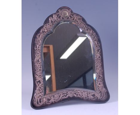 A late Victorian ebony and silver mounted easel dressing table mirror, having a shaped bevelled plate within a pierced silver