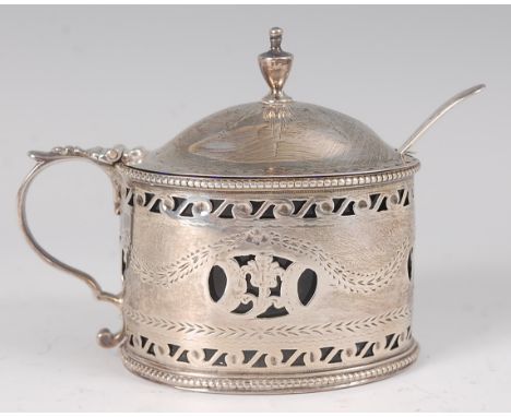 A George III silver mustard pot, having a finial topped hinged dome cover, blue glass liner, pierced frieze and apron, with f