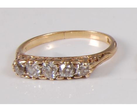 An early 20th century yellow metal five stone diamond half hoop ring, featuring five graduated Old European cut diamonds in c