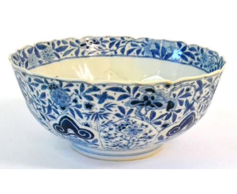 A Chinese Porcelain Bowl, Kangxi, of fluted and leaf scroll moulded circular form, painted in underglaze blue with scrolling 