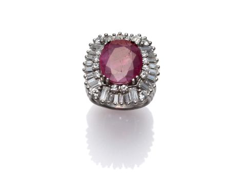 A Ruby and Diamond Cluster Ring, the oval cut ruby within a border of round brilliant and baguette cut diamonds, in white cla