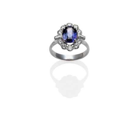 An 18 Carat White Gold Sapphire and Diamond Cluster Ring, the two tone sapphire of purple and green hues within a border of r