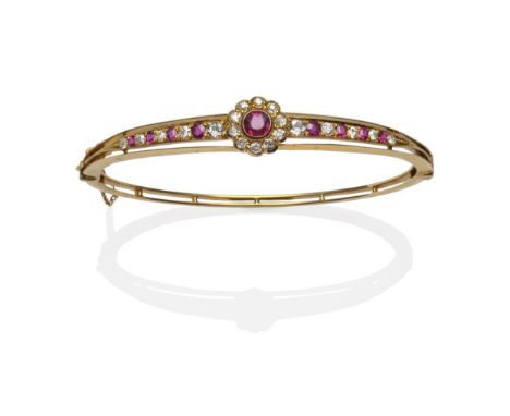 A Ruby and Diamond Bangle, circa 1880, a ruby and diamond cluster in yellow rubbed over settings flanked by a graduating row 