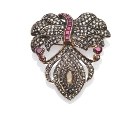 An Indian Ruby and Diamond Brooch/Pendant, in feather form, set with rose cut diamonds and calibré cut rubies, measures 4.4cm