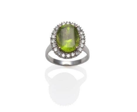 An 18 Carat White Gold Peridot and Diamond Cluster Ring, an oval cut peridot within a border of round brilliant cut diamonds,