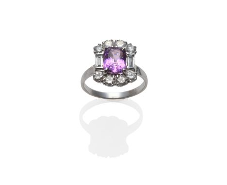 An 18 Carat White Gold Pink Sapphire and Diamond Cluster Ring, the cushion cut purpley-pink sapphire flanked by a baguette cu