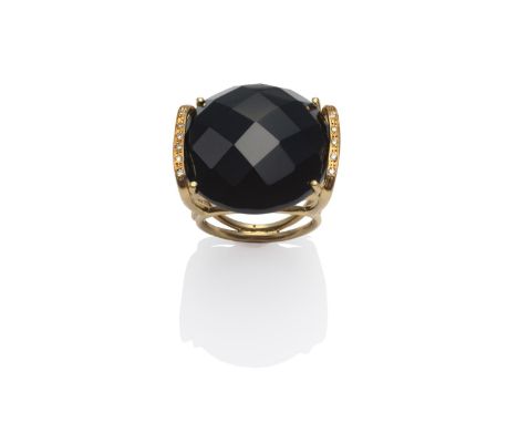 An Onyx and Diamond Ring, a round faceted onyx in a bar setting, with round brilliant cut diamonds, on a yellow shank, finger