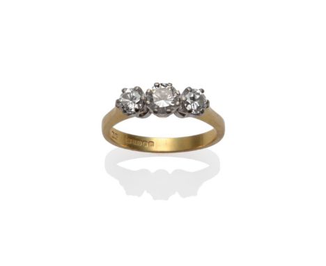 An 18 Carat Gold Diamond Three Stone Ring, the graduated round brilliant cut diamonds in white claw settings, to a yellow tap