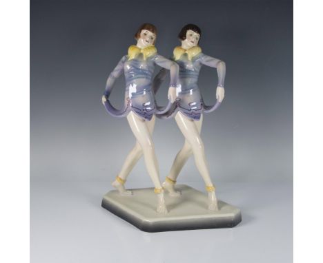 Model 5612. Twin sisters figures of dancers in yellow fur collars and purple dress. On a diamond base. Goldscheider WMG marke