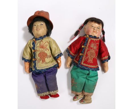 Two Oriental inspired dolls, one with bisque head the other with plastic head, both wearing silk jackets and trousers decorat