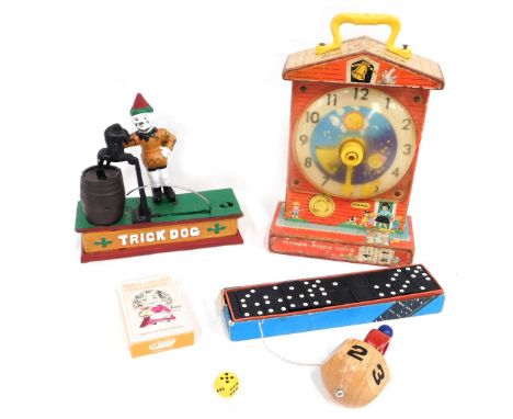 A novelty trick dog money box, 18cm high, 19cm wide, a Fisher Price music box teaching clock, cased set of dominoes, playing 