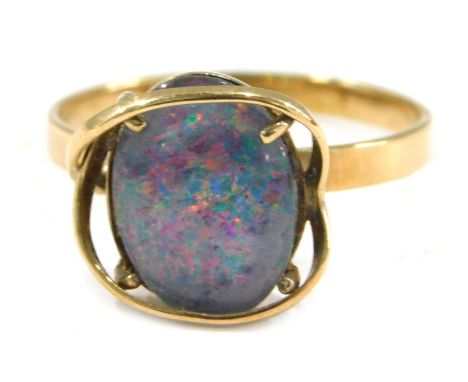 An imitation opal dress ring, the imitation opal doublet, with dark blue flare, in a raised yellow metal coloured mount, on y