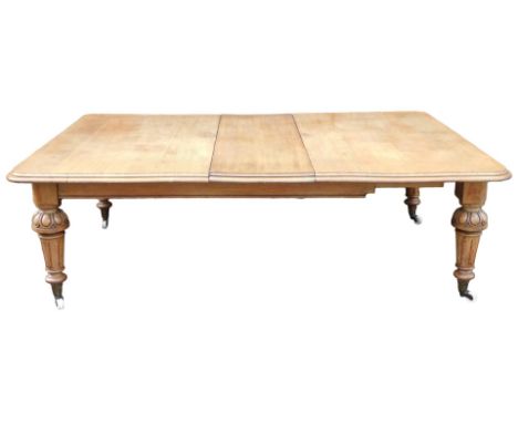 A Victorian oak extending dining table, the rectangular top with a moulded edge, on turned and fluted tapering legs, with bra