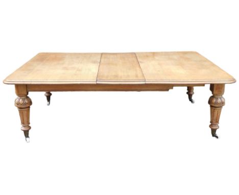 A Victorian oak extending dining table, the rectangular top with a moulded edge, on turned and fluted tapering legs, with bra