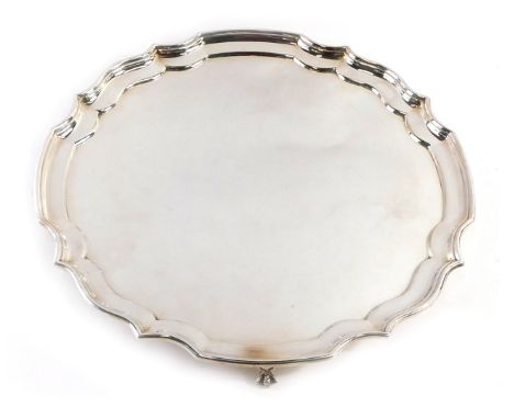 A 20thC silver plated salver, with piecrust border, on four ball and claw feet, stamped EPNS, 35cm diameter. 