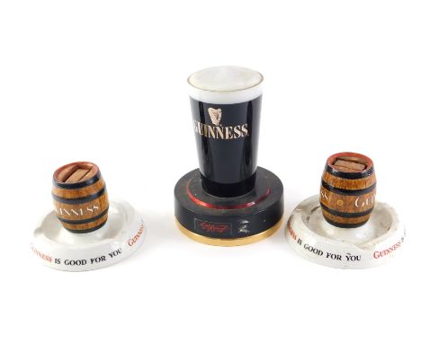 A Mintons Guinness match striker, another similar, and a Guinness lamp. (3) 