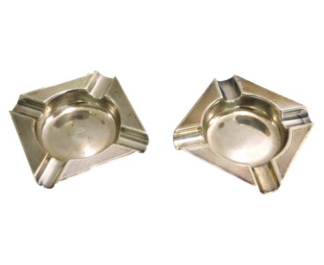 A matched pair of George V silver ashtrays, each of square form, with engine turned border, Birmingham 1913 and 1914, 2oz. (2