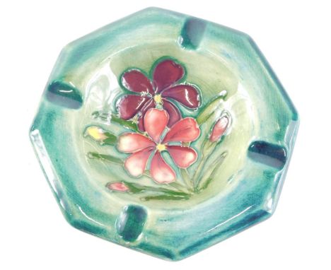 A Moorcroft spring flowers pattern ceramic ash tray, on a blue glazed hexagonal ground, 12cm diameter. 