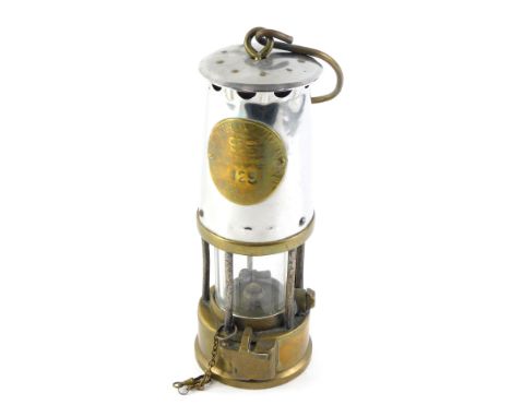 A Protector polished steel and brass miner's lamp, numbered 129, possibly Type 6, 25cm high.