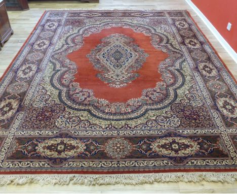 A super Kashan wool carpet, the red field with multi floral patterned border and central medallion, 275 x 360cm 