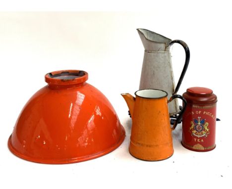 A vintage orange enamel light shade, 35cmD, together with several enamel jugs, a trivet and a tea canister 