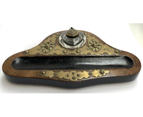 A late Victorian inkwell, the mahogany stand with brass mounts and pen rest, 32cmW 