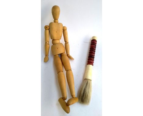 An artist's wood mannequin, 52cmH, together with a large brush with hard stone handle, 37cmL 