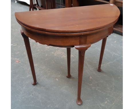 A 20th century mahogany demilune card table, fold over top on tapered legs and pad feet, 81x74cmH 