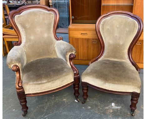A pair of Victorian mahogany framed and carved button upholstered salon chairs, one with arms, on turned legs and ceramic cas