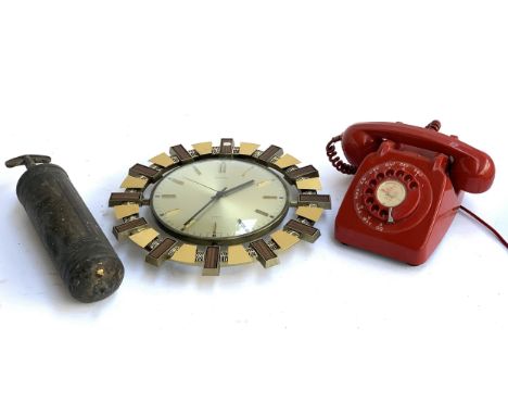 A vintage red rotary dial telephone, labelled Upway 2646, a Metamec quartz wall clock and an antique fire extinguisher 