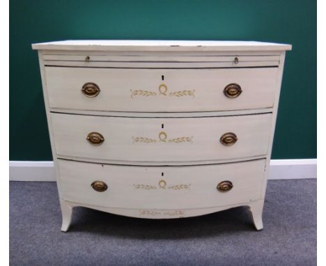 An early 19th century and later parcel gilt white painted bowfront chest, with brushing slide over three long graduated drawe